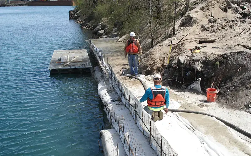 Brennan crew installing concrete reinforcement for shoreline stabilization along the water’s edge.